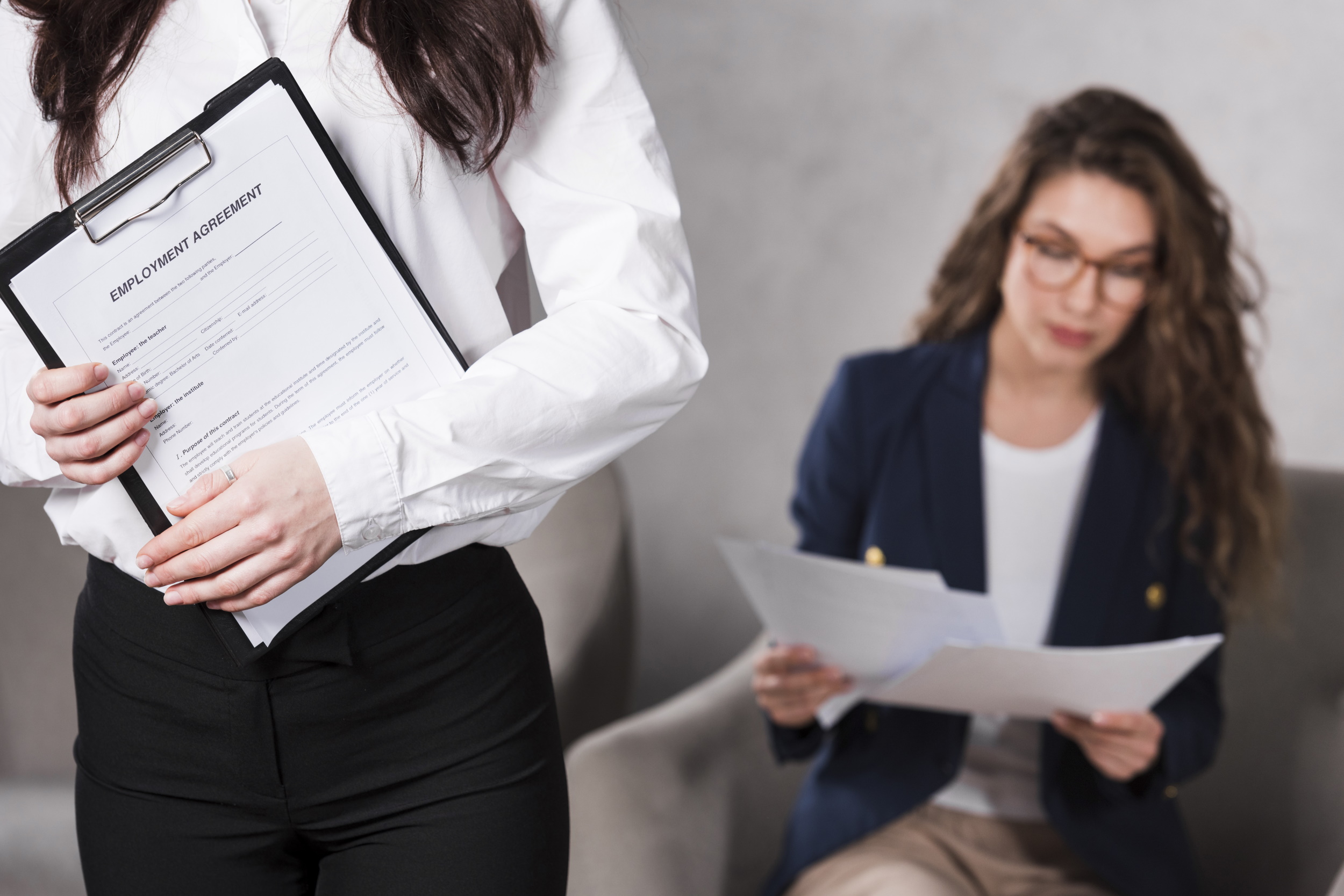 front-view-of-woman-holding-contract-and-another-one-reading-papers